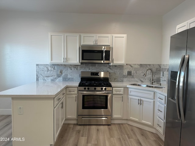 kitchen with sink, stainless steel appliances, light hardwood / wood-style floors, and tasteful backsplash