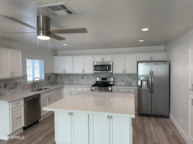 kitchen with ceiling fan, white cabinets, light hardwood / wood-style floors, sink, and stainless steel appliances