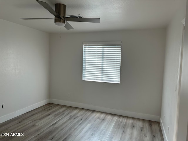 spare room with ceiling fan and light wood-type flooring