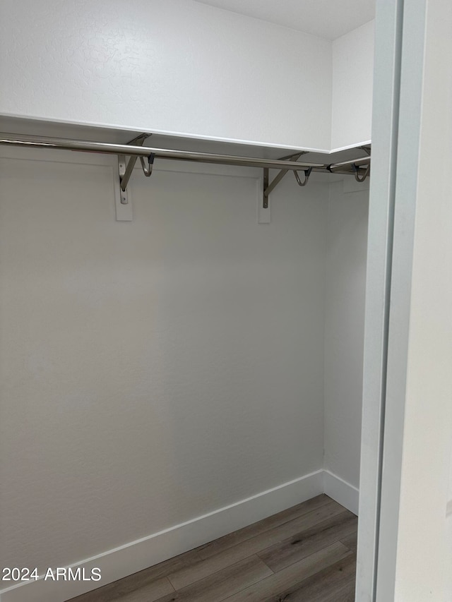 walk in closet with hardwood / wood-style floors