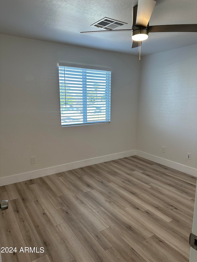 spare room featuring hardwood / wood-style flooring, a textured ceiling, and ceiling fan