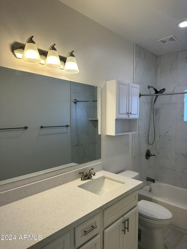 full bathroom featuring tile patterned floors, tiled shower / bath, vanity, and toilet