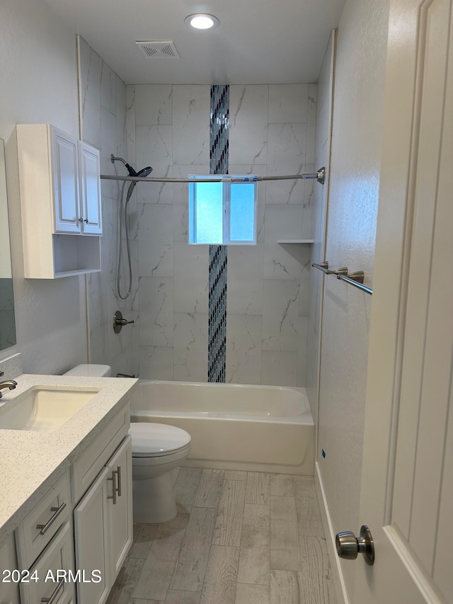 full bathroom featuring toilet, tiled shower / bath combo, vanity, and wood-type flooring