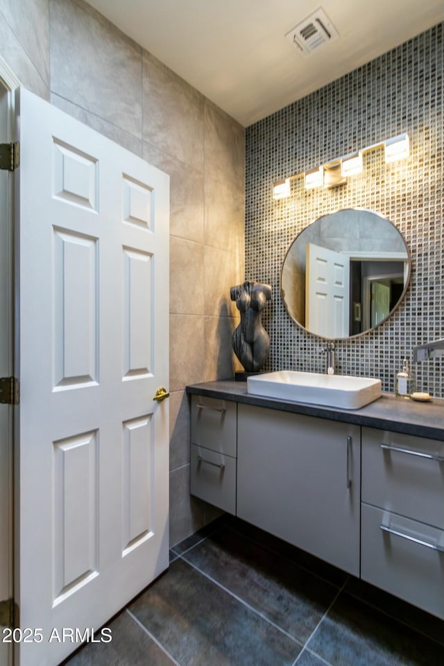 bathroom featuring tile patterned floors, vanity, and tile walls