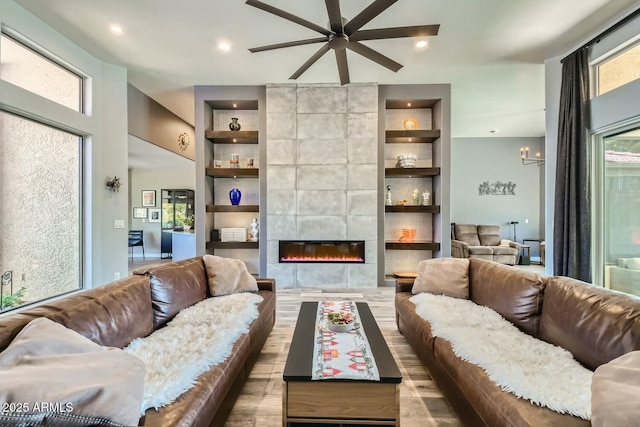 living room with a fireplace, built in features, and light wood-type flooring