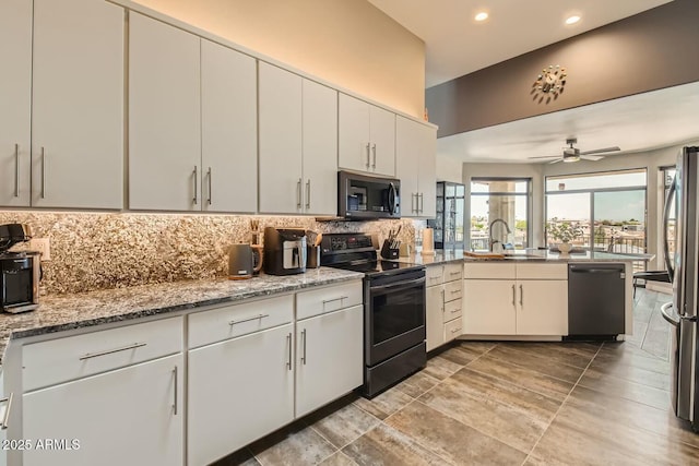 kitchen with sink, white cabinetry, light stone counters, stainless steel appliances, and backsplash