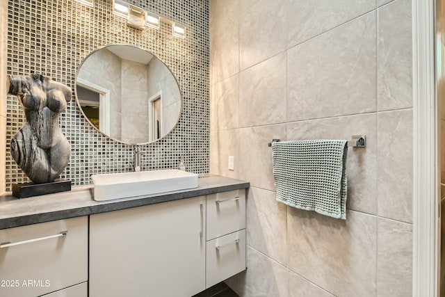 bathroom with decorative backsplash, vanity, and tile walls