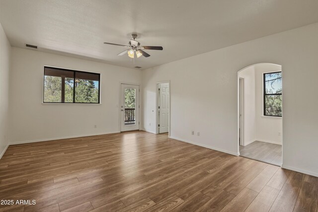 502 W Locust Rd, Payson, AZ 85541 - unfurnished room featuring healthy amount of natural light, ceiling fan, arched walkways, and wood finished floors