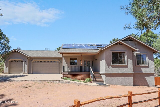 502 W Locust Rd, Payson, AZ 85541 - view of front of house with covered porch, a garage, stucco siding, and roof mounted solar panels