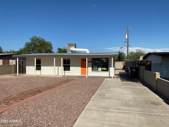 view of front of property with fence, stucco siding, a gate, and concrete driveway