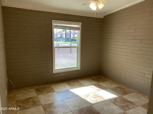 empty room with plenty of natural light, a ceiling fan, ornamental molding, and stone finish flooring