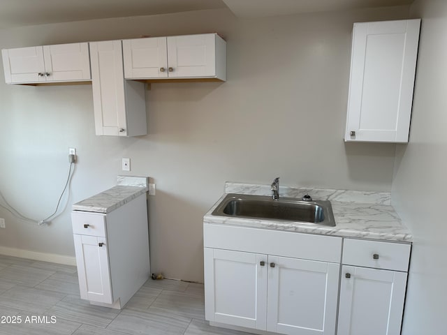 laundry room featuring a sink and baseboards