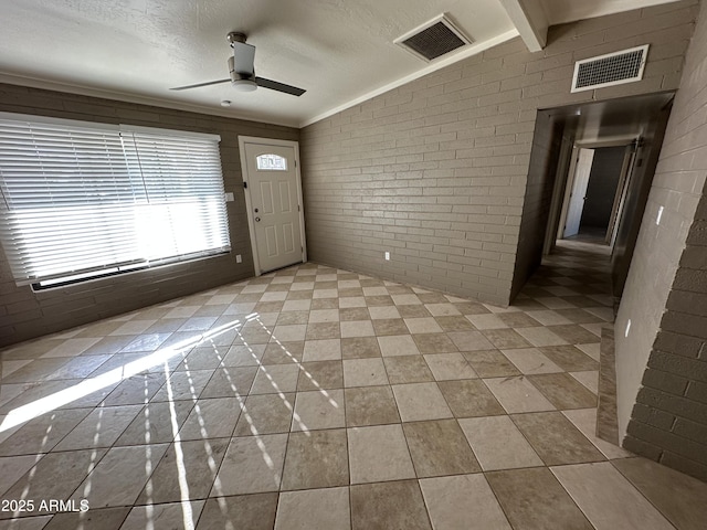 entrance foyer featuring ceiling fan, lofted ceiling, brick wall, and a textured ceiling