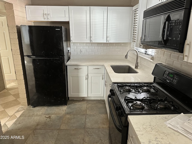 kitchen featuring black appliances, a sink, decorative backsplash, white cabinetry, and light stone countertops