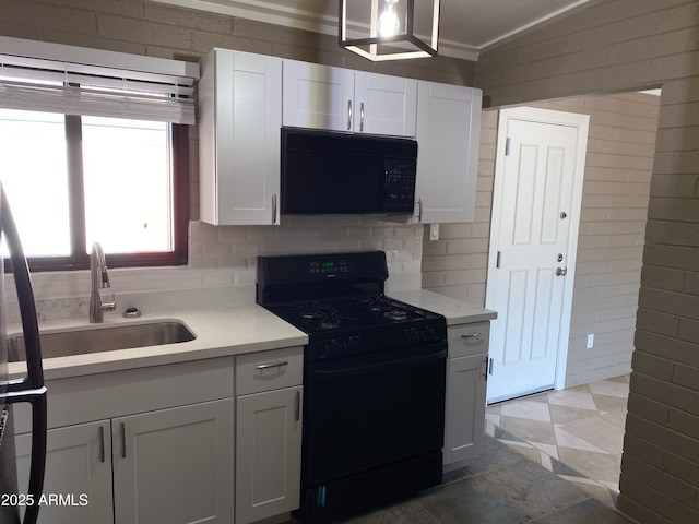 kitchen with black appliances, light countertops, a sink, and white cabinetry