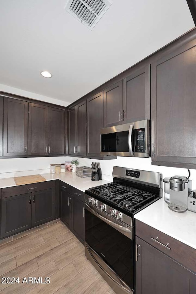 kitchen featuring stainless steel appliances and dark brown cabinets