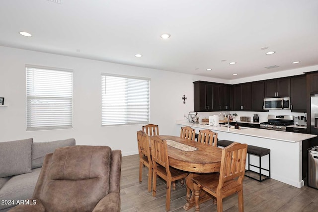 dining space with sink and light hardwood / wood-style flooring