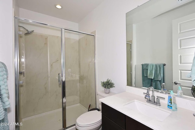 bathroom with toilet, a shower with shower door, and vanity