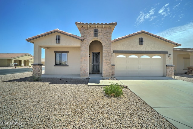 mediterranean / spanish-style house with a garage