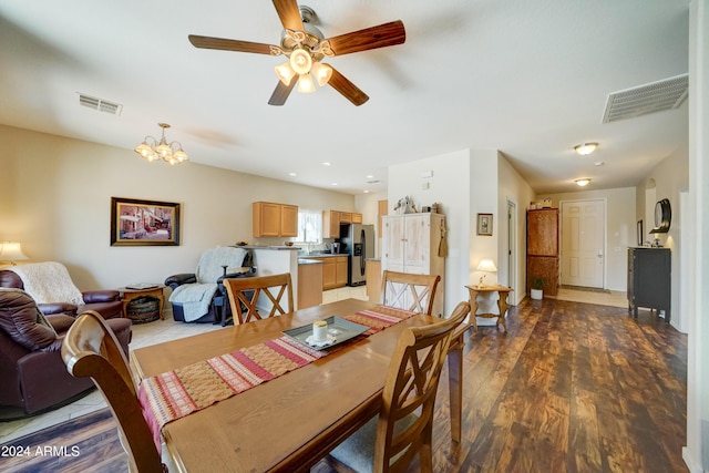 dining room featuring ceiling fan with notable chandelier and hardwood / wood-style flooring