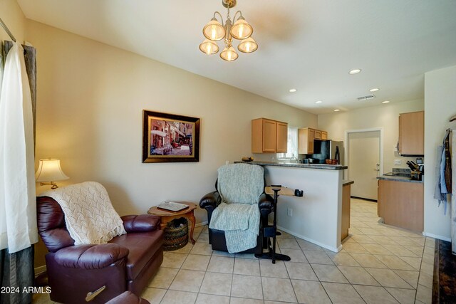 living area featuring a notable chandelier and light tile patterned flooring