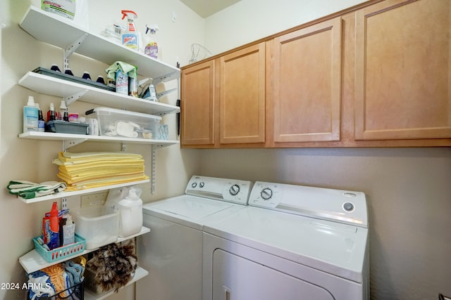 laundry area featuring washing machine and dryer and cabinets