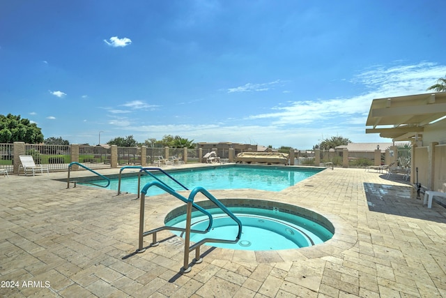 view of swimming pool with a patio area and a community hot tub