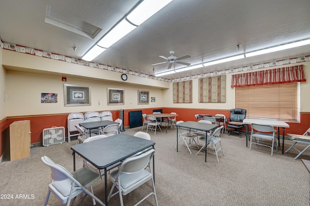 carpeted dining room with ceiling fan and a textured ceiling