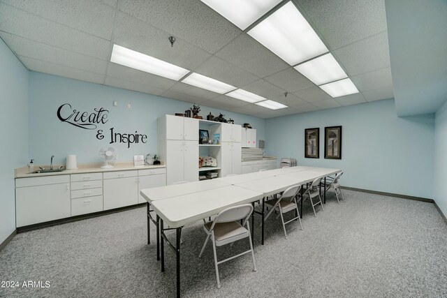 kitchen featuring light carpet, white cabinets, a paneled ceiling, and sink