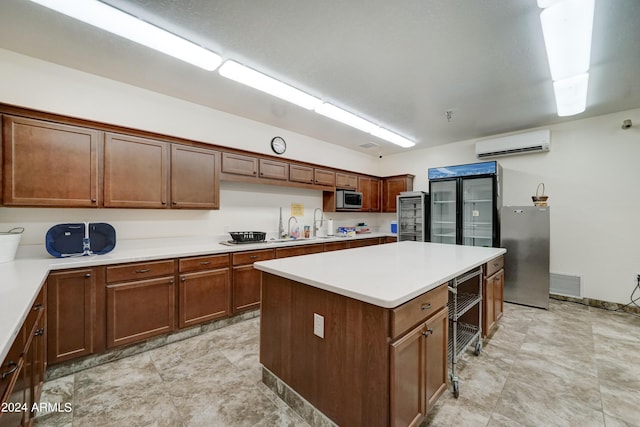 kitchen with appliances with stainless steel finishes, sink, a center island, and a wall mounted air conditioner