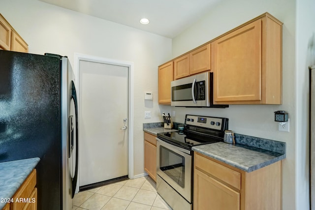 kitchen featuring light tile patterned floors, stainless steel appliances, and light brown cabinets