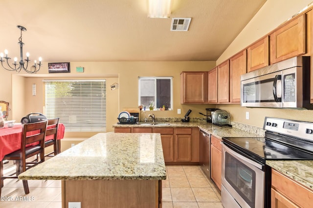 1619 E Aspen Ave, Buckeye, AZ 85326 - kitchen with stainless steel appliances, light tile patterned flooring, a center island, a chandelier, and lofted ceiling