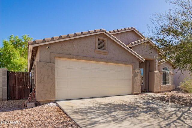 1619 E Aspen Ave, Buckeye, AZ 85326 - view of front facade with an attached garage, stucco siding, driveway, a gate, and a tiled roof