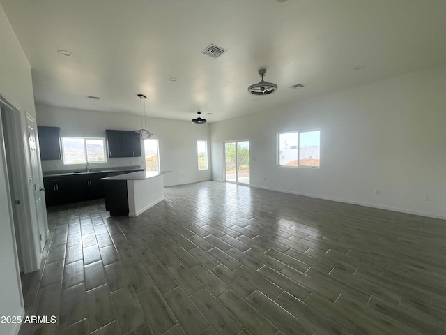 1825 Via Nueva Zelandia, Rio Rico, AZ 85648 - unfurnished living room with healthy amount of natural light, dark wood finished floors, baseboards, and ceiling fan