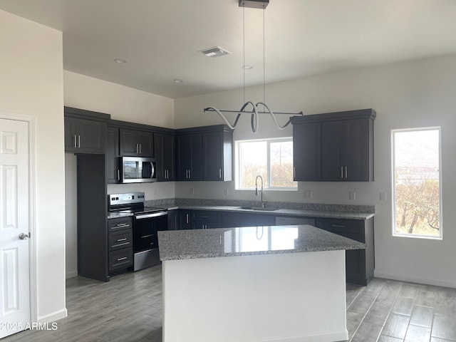 1825 Via Nueva Zelandia, Rio Rico, AZ 85648 - kitchen featuring stainless steel appliances, a sink, light stone counters, and light wood-style flooring