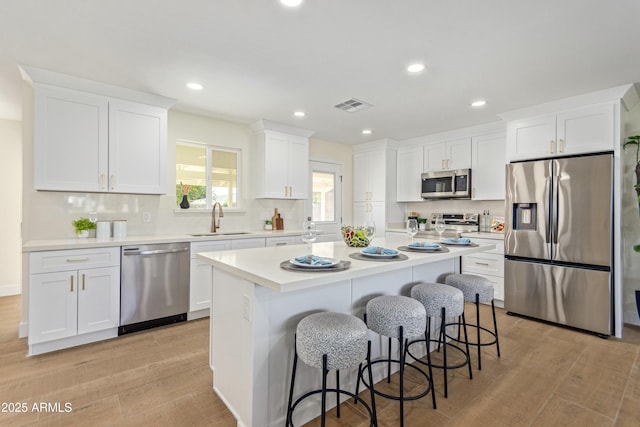 kitchen featuring white cabinets, stainless steel appliances, light hardwood / wood-style flooring, and sink