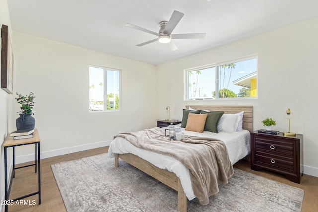 bedroom with multiple windows, ceiling fan, and light hardwood / wood-style flooring