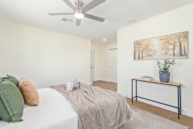 bedroom with a closet, ceiling fan, and light hardwood / wood-style flooring