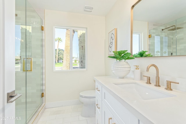 bathroom featuring tile patterned floors, vanity, toilet, and a shower with shower door