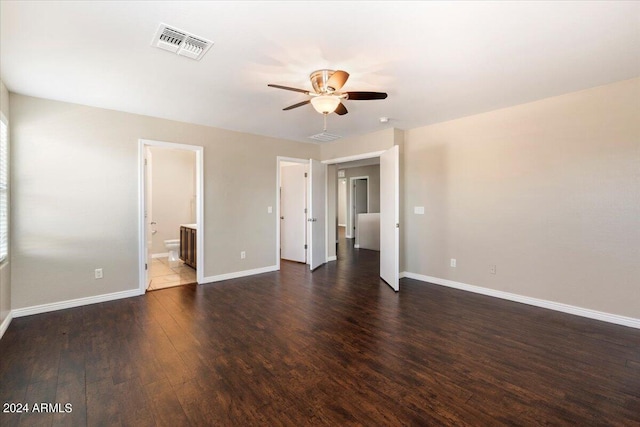 unfurnished bedroom with ceiling fan, dark hardwood / wood-style floors, and connected bathroom