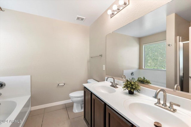 bathroom with a washtub, vanity, tile patterned floors, and toilet