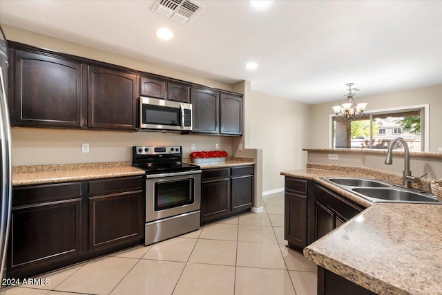 kitchen featuring appliances with stainless steel finishes, dark brown cabinetry, sink, pendant lighting, and an inviting chandelier