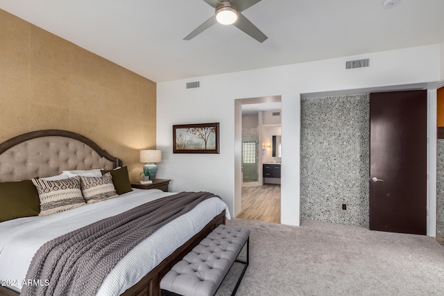 bedroom featuring carpet floors, ceiling fan, and ensuite bath