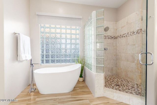 bathroom with plus walk in shower and hardwood / wood-style flooring