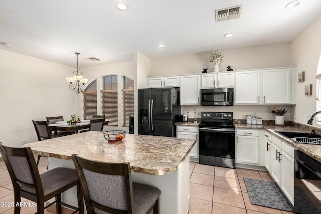 6505 S 15th Dr, Phoenix, AZ 85041 - kitchen with black appliances, a sink, a chandelier, white cabinets, and light tile patterned floors