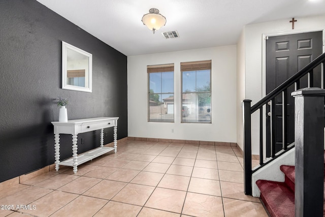 6505 S 15th Dr, Phoenix, AZ 85041 - entryway featuring stairway, light tile patterned flooring, a textured wall, and baseboards