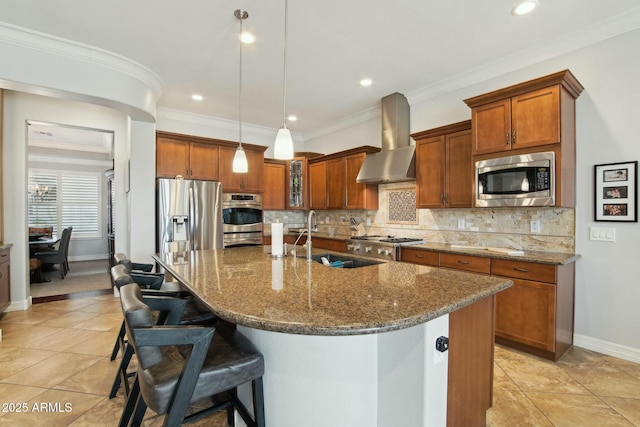 kitchen with brown cabinets, stainless steel appliances, a kitchen bar, backsplash, and wall chimney exhaust hood