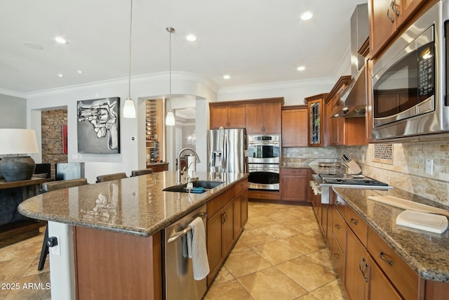 kitchen with a breakfast bar area, stainless steel appliances, a sink, decorative backsplash, and brown cabinetry