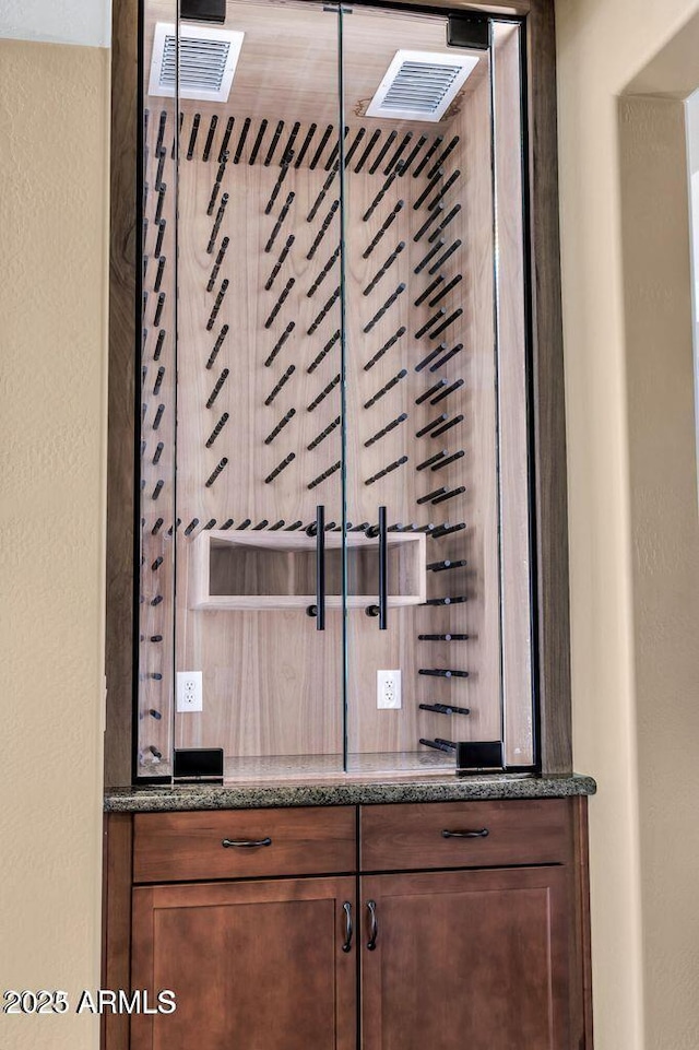 wine cellar with visible vents and a textured wall