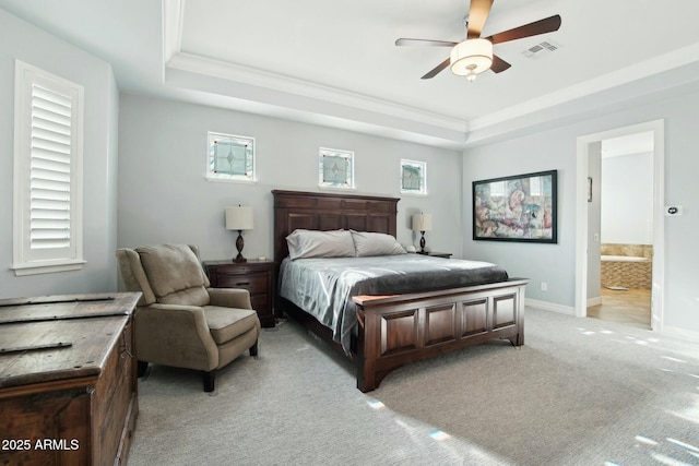 bedroom with light colored carpet, visible vents, baseboards, ornamental molding, and a raised ceiling